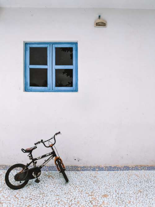 Small Bike Under Blue Window Frame Photo