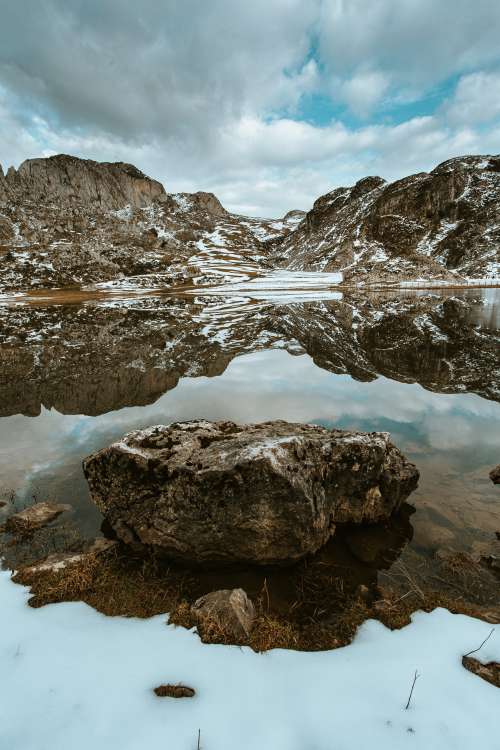 A Rock Stands In The Middle Of The Lake Photo