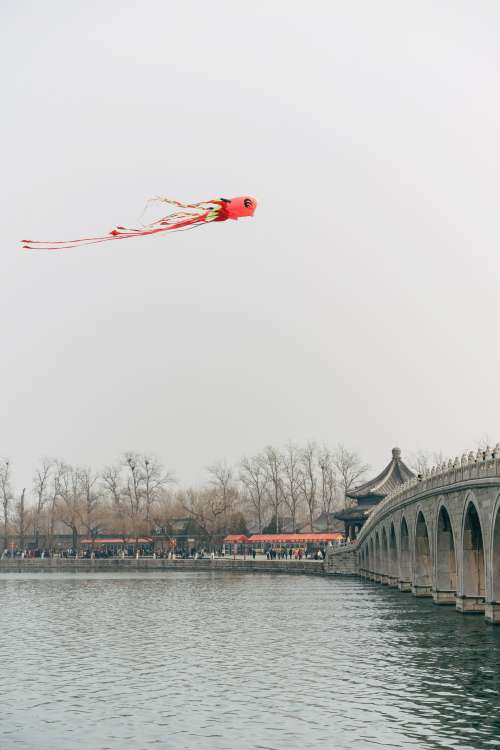 Chinese Flying Kite Over A River Photo