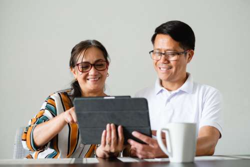 Couple Smile As The Use A Tablet Photo