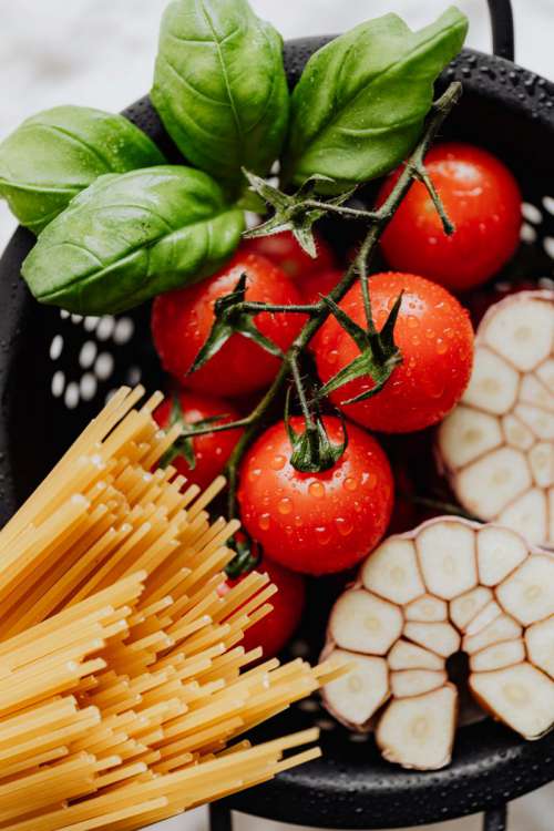Detail of cherry tomatoes with drops of water and spaghetti