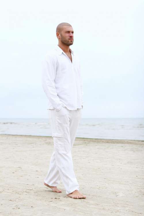 Man in white walking on the beach
