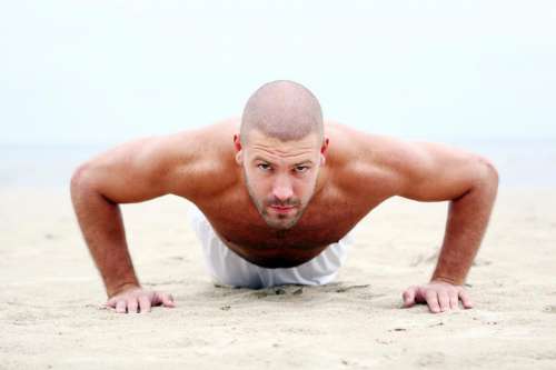 Doing pushups on the sandy beach