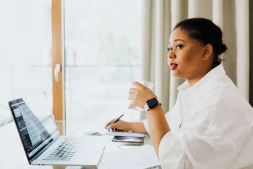 A young woman works on a laptop from home