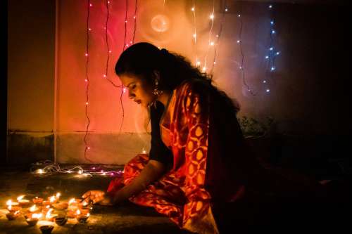 Young Woman Places Diwali Candles Photo