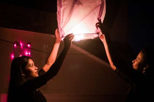 Two People Raising A Lantern Photo