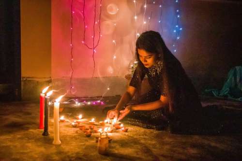 Young Woman Lights Candles For Diwali Photo