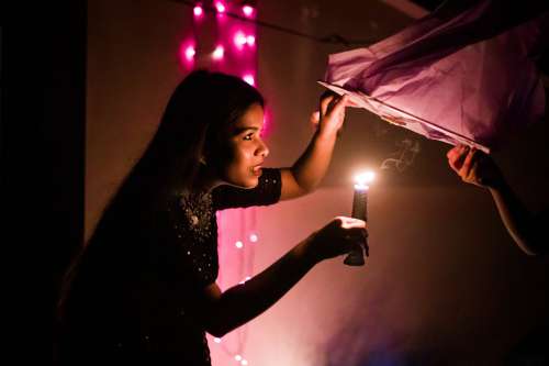 Young Woman Places Candle Inside Lantern Photo