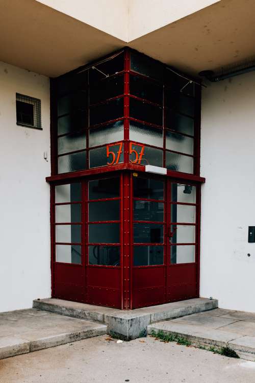 A Symmetrical Building Entrance With Red Doors Photo