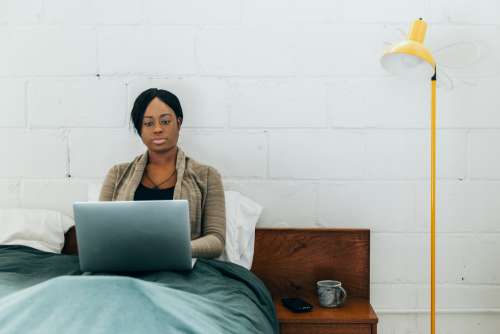 Women Sits In Bed With Laptop And Coffee Photo