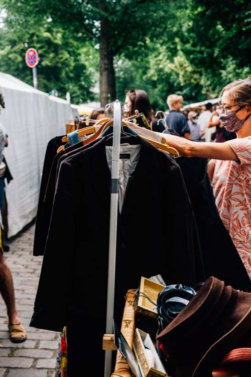 Person Shops For Clothes In An Outdoor Market Photo