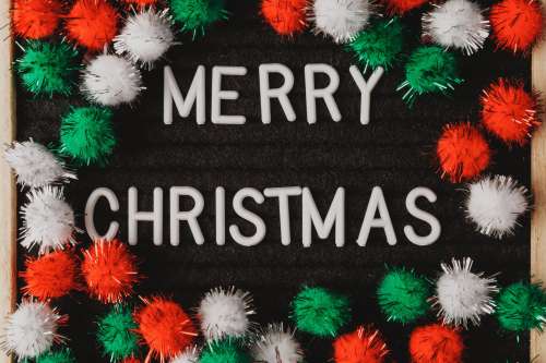 Fuzzy Decorations Surround The Words Merry Christmas Photo