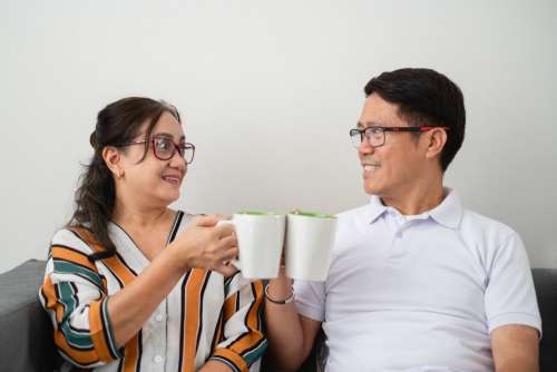 Two People Cheers With Coffee Cups Photo