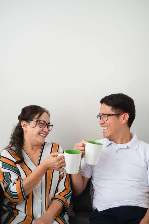 Two People Laugh As They Look Towards Each Other Photo