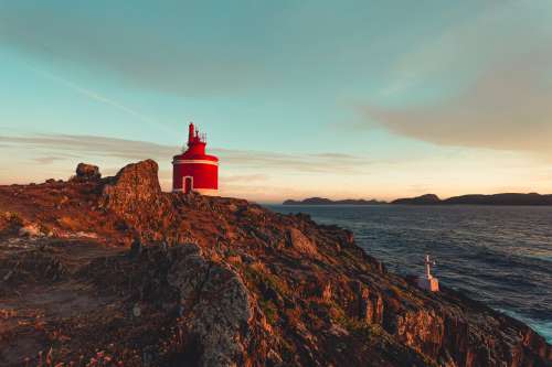 Small Red Lighthouse In The Rocks Photo