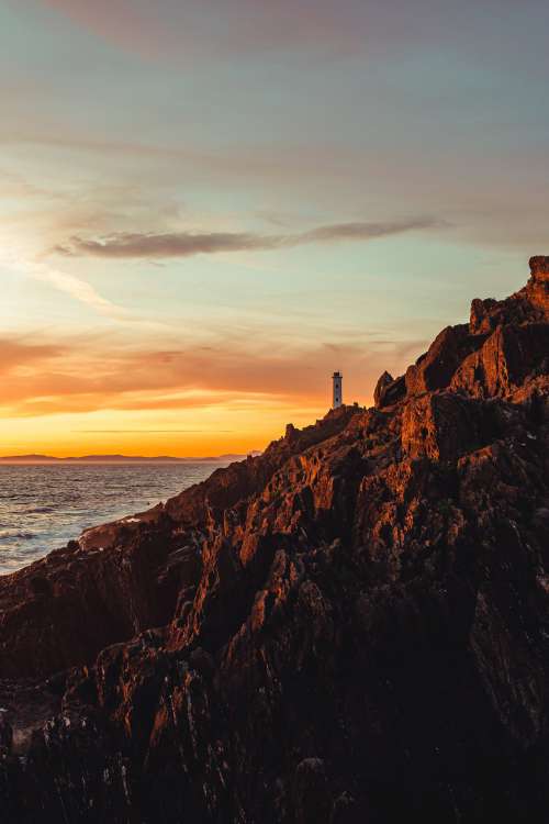 Lighthouse On Steep Cliffside Photo