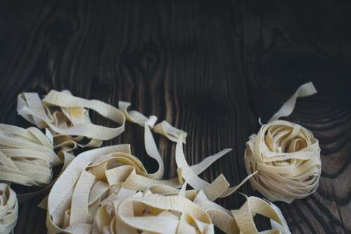 Pasta tagliatelle on a wooden background