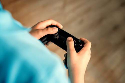 Young boy gaming and holding gamepad