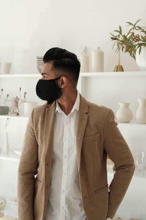 Man Standing In Store Wearing A Black Cloth Face Mask Photo