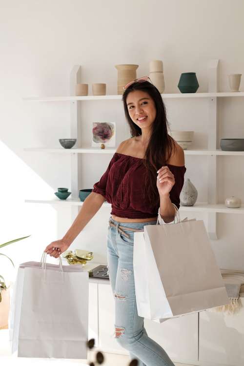 Happy Customer Smiles And Holds White Shopping Bags Photo