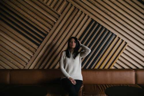 A Woman Sits Against Large Wooden Wall Photo