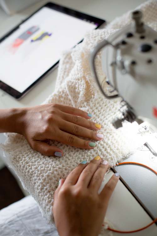 Hands Line Up Fabric Into A Sewing Machine Photo