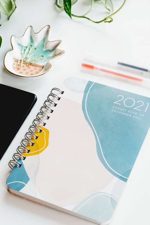 A 2021 Note Book Surrounded By Supplies Photo