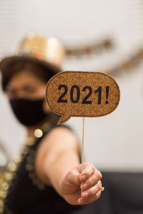 Woman Holds Up Small Happy 2021 Sign Photo