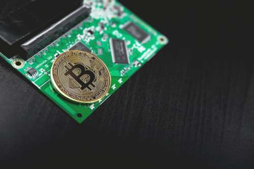 Bitcoin concept – Printed circuit board with bitcoin processor and microchips
