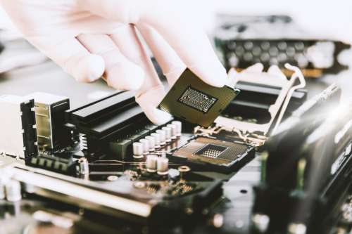 The technician is putting the CPU on the socket of the computer motherboard