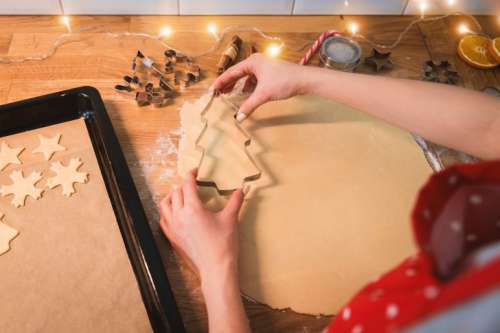 Woman bakes cookies. Symbol of heart in flour on a wooden table in the kitchen