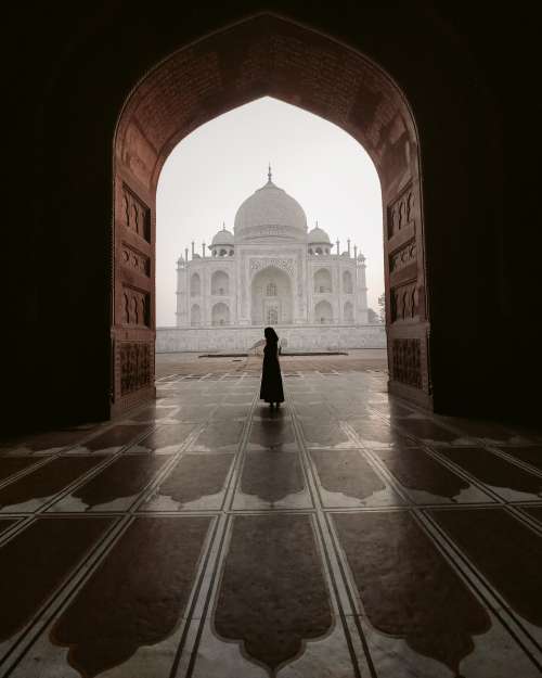 The Silhouette Of A Person Standing In A Carved Archway Photo