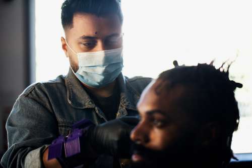 Barber Wears A Face Mask While Cutting Hair Photo