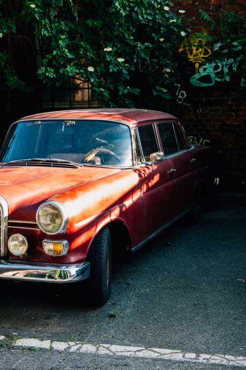 Red Vintage Car Parked By Brick Wall Photo