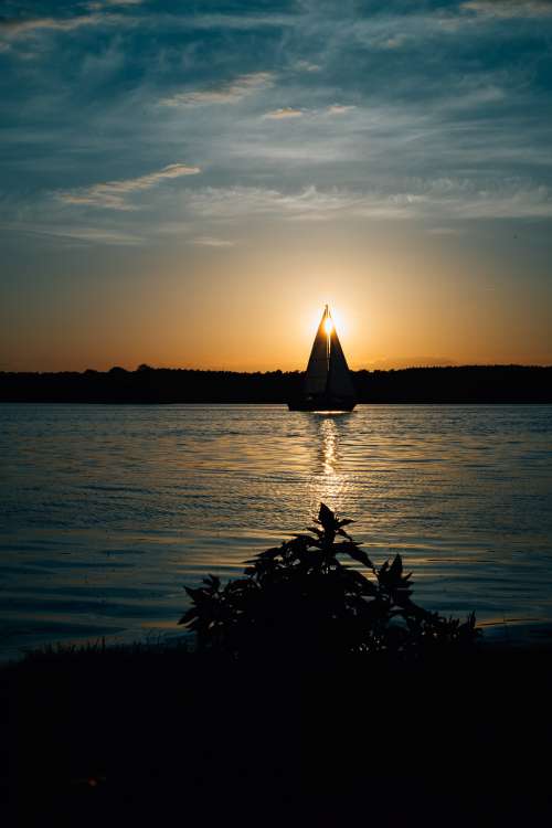 Sail Boat On Quiet Lake At Sunset Photo