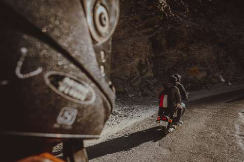 Two People Ride A Motorbike On A Dirt Road Photo