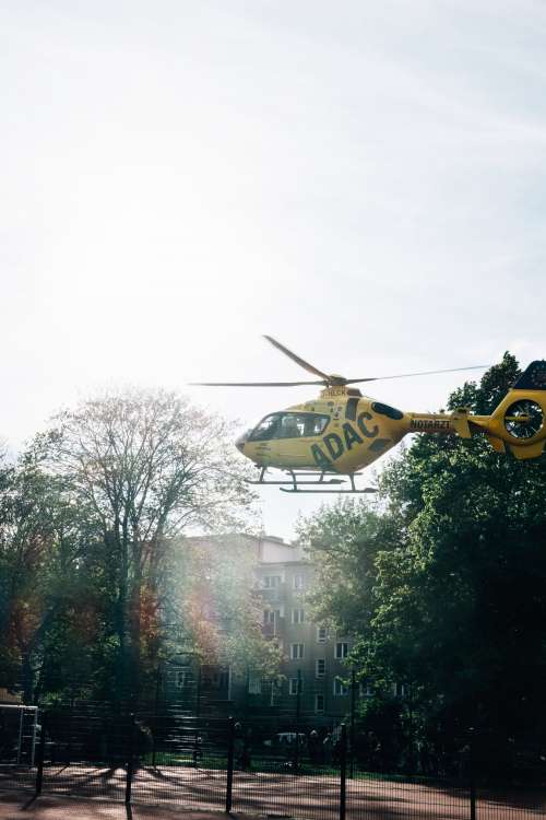 Yellow Helicopter Lands In Town Photo