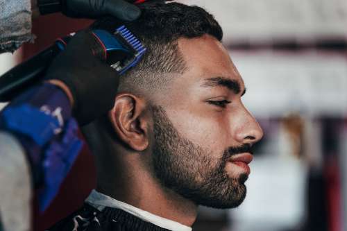 Man Gets His Hair Trimmed At The Barbershop Photo