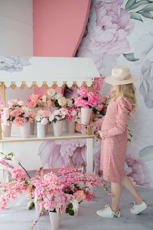 Person Stands By Pink Flower Stand In Polka Dot Dress Photo