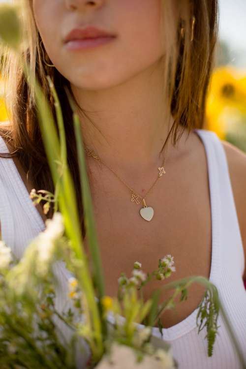 Close Up Of A Gold Necklace On A Person In A White Shirt Photo