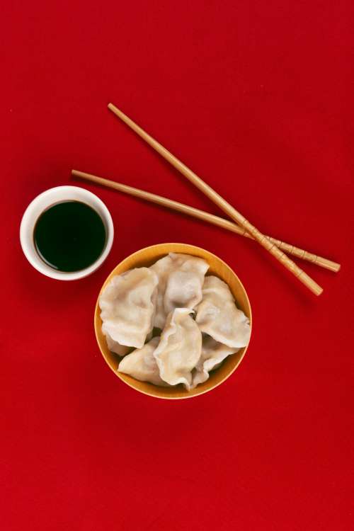 Dumplings Chopsticks And Sauce On A Red Cloth Viewed From Above Photo