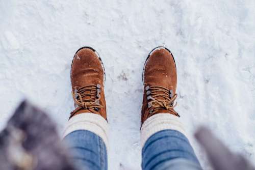 Female feet standing on a snow-covered pavement
