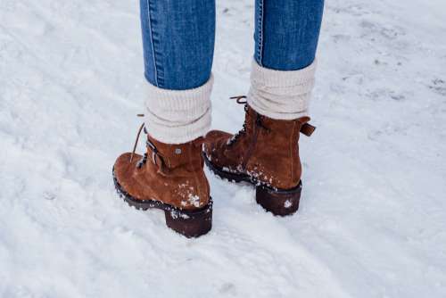 Female feet standing on a snow-covered pavement 2