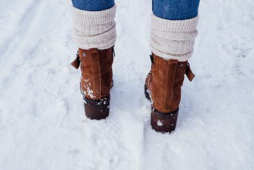 Female feet standing on a snow-covered pavement 3