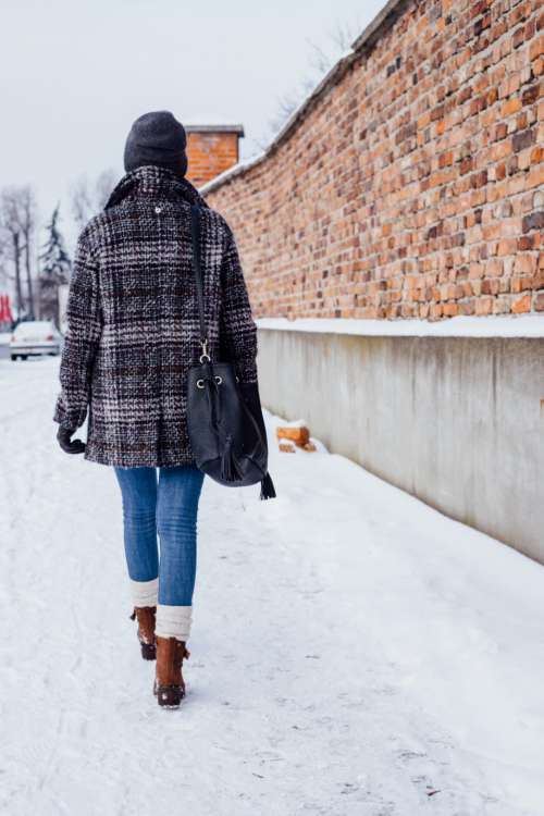 A female walking on a snow-covered pavement