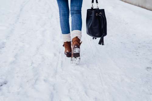 A female walking on a snow-covered pavement 4