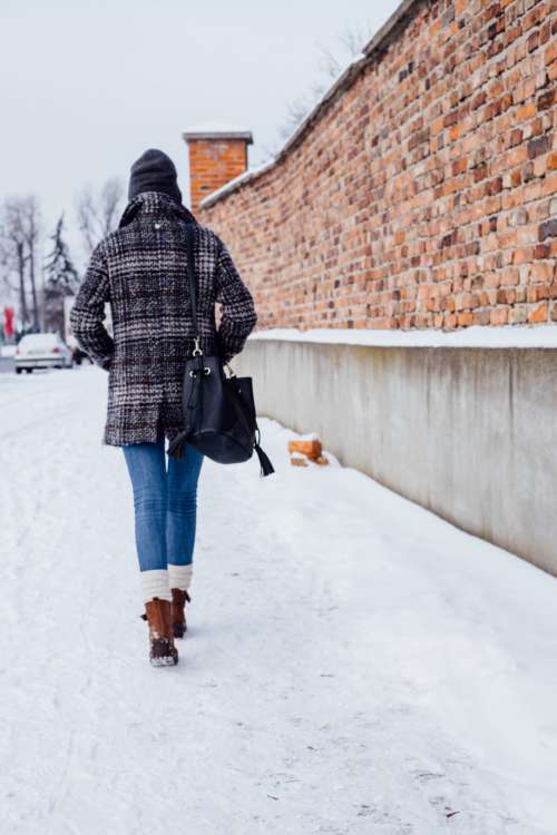 A female walking on a snow-covered pavement 2