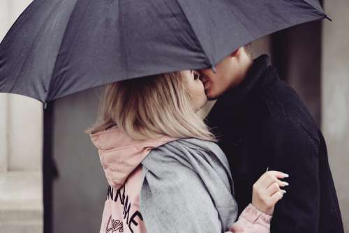 A couple kissing under an umbrella 2