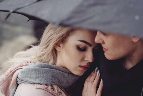 A couple hugging under an umbrella closeup