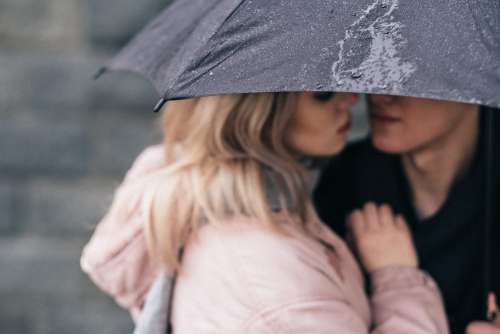 A couple hugging under an umbrella closeup 2